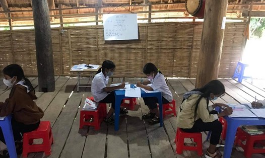 Các em học sinh ở Kon Tum tập trung học bài ở nhà rông. Ảnh T.T