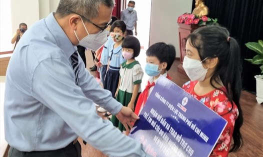 Ông Nguyễn Văn Thanh, Tổng giám đốc EVNHCMC, trao biển tượng trưng hỗ trợ cho các trẻ em có cha, mẹ chết vì COVID-19. Ảnh: Nam Dương