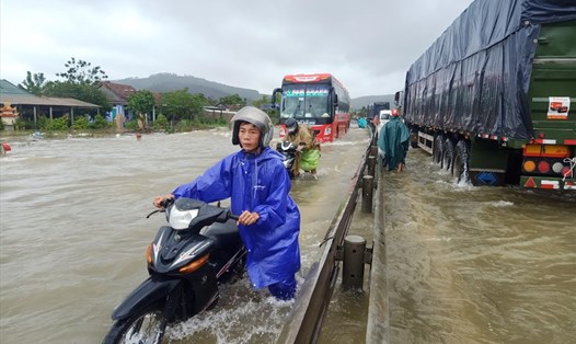 Quốc lộ 1A đoạn qua xã Lộc Trì (huyện Phú Lộc, Thừa Thiên Huế) bị ngập cục bộ khiến phương tiện lưu thông khó khăn, nhiều xe chết máy. Ảnh: PĐ.