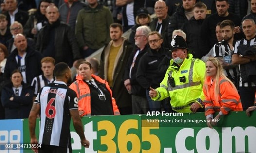 Các nhân viên an ninh trao đổi thông tin về sự cố của cổ động viên với đội trưởng Newcastle Jamaal Lascelles. Ảnh: AFP