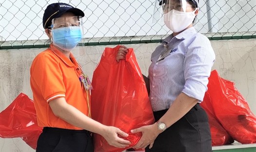 Bà Trần Thị Hồng Vân (bên phải) - Chủ tịch Công đoàn Công ty Nissei Electric Việt Nam tặng quà cho công nhân đi làm trở lại. Ảnh: Đức Long