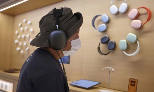 Một khách hàng nghe nhạc tại cửa hàng của Apple. Ảnh minh họa. Ảnh: Reuters