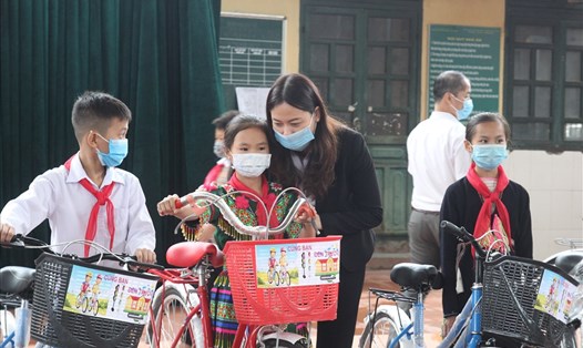 Lãnh đạo huyện Văn Yên trao xe và động viên các em học sinh vượt khó đến trường. Ảnh: Văn Đức.