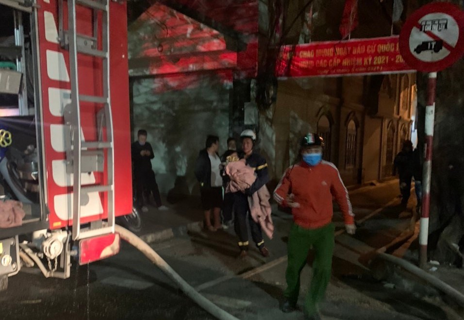 Lực lượng chức năng đưa cháu bé ra khỏi đám cháy. Ảnh Công an Hải Phòng