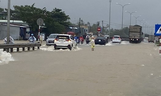 Quốc lộ 1A ở Quảng Nam bị ngập sâu, lực lượng chức năng phải túc trực điều tiết giao thông. Ảnh: Cảnh sát giao thông
