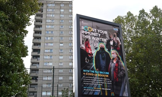 Poster quảng cáo chiến dịch tiêm chủng của Bộ Y tế Anh tại một khu dân cư ở London. Ảnh: NHS