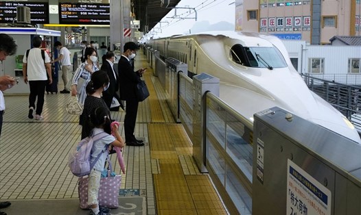 Người dân đứng chờ tàu trên một sân ga ở Nhật Bản. Ảnh: AFP.