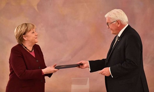 Tổng thống Đức Frank-Walter Steinmeier trao quyết định kết thúc nhiệm kỳ cho Thủ tướng Angela Merkel tại Cung điện Bellevue ở Berlin ngày 26.10.2021. Ảnh: AFP