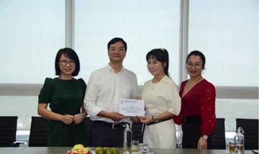 Phó Chủ tịch Công đoàn Điện lực Việt Nam Lương Bá Thanh (thứ hai từ trái sang) trao 20 triệu đồng hỗ trợ cho lãnh đạo Trung tâm Thông tin Điện lực.