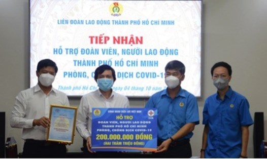 Ông Phạm Chí Tâm - Phó Chủ tịch LĐLĐ tỉnh TP.Hồ Chí Minh (thứ hai từ phải sang) nhận hỗ trợ 200 triệu đồng từ Công đoàn Điện lực Việt Nam.