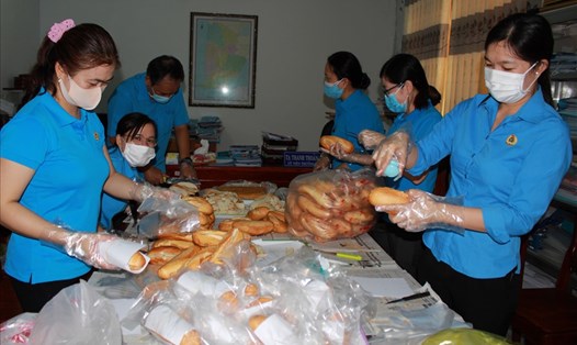 Cán bộ Công đoàn Cà Mau trực tiếp làm bành mì hỗ trợ thức ăn nhanh cho người dân từ vùng dịch về quê hương Cà Mau.