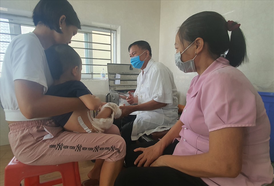 Ông Thoàn "bỏng" thay băng, đắp thuốc cho một bệnh nhi 3 tuổi bị bỏng cả hai chân đến từ TP.Thái Bình. Ảnh: T.D