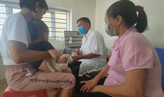 Ông Thoàn "bỏng" thay băng, đắp thuốc cho một bệnh nhi 3 tuổi bị bỏng cả hai chân đến từ TP.Thái Bình. Ảnh: T.D