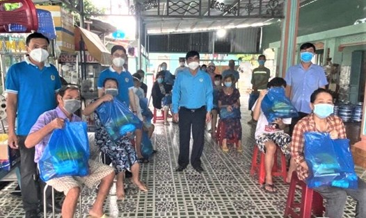 Đại diện LĐLĐ huyện Hóc Môn trao các túi an sinh của Tổng LĐLĐ Việt Nam đến đoàn viên công đoàn, CNLĐ ở nhà trọ. Ảnh: Đức Long