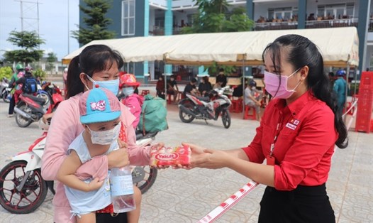 Bà Lê Thị Hồng Thanh (Công ty TNHH Yakult Việt Nam tại tỉnh Đồng Tháp) trao sữa trực tiếp cho trẻ em tại khu cách ly. Ảnh: Hùng Lưu