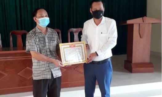 Lãnh đạo Ủy ban Mặt trận Tổ quốc Việt Nam huyện Triệu Phong (bìa trái ảnh) trao giấy chứng nhận tấm lòng vàng cho người đại diện của nghệ sĩ Hoài Linh. Ảnh: MT.