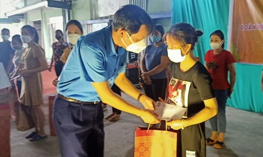 Lãnh đạo Liên đoàn Lao động tỉnh Hải Dương trao quà tặng nữ công nhân có gia đình 11 người mắc COVID-19. Ảnh Diệu Thuý