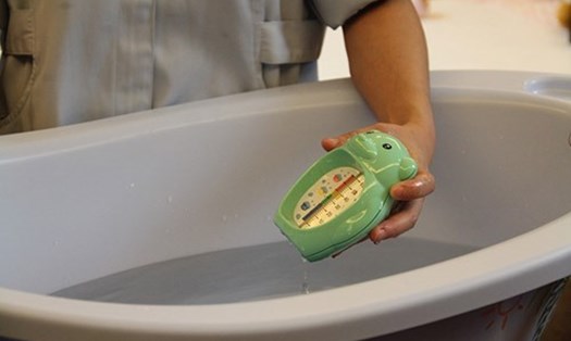Kiểm tra nhiệt độ nước để đảm bảo sức khoẻ khi tắm cho bé. Ảnh: GG
