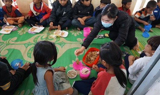 Cô giáo thêm món cá khô cho các em học sinh ở điểm trường Kon Du. Ảnh T.T