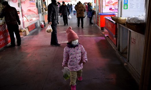 Một bé gái xách túi rau xanh khi đi chợ cùng người thân ở Bắc Kinh, Trung Quốc. Ảnh minh họa. Ảnh: AFP