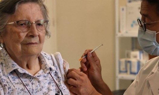 Một người cao tuổi tiêm liều vaccine COVID-19 nhắc lại ở Paris, Pháp. Ảnh: AFP