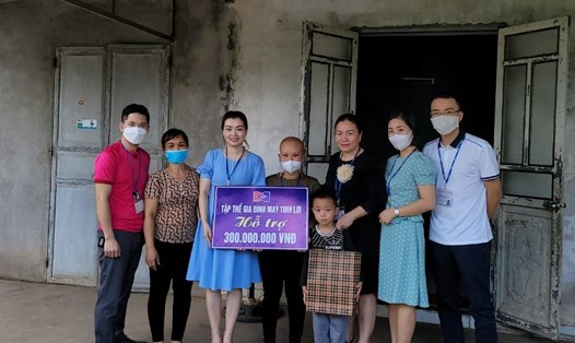 Công nhân Trịnh Thị Hoa nhận hỗ trợ 300 triệu đồng từ Công đoàn Công ty TNHH May Tinh Lợi. Ảnh Diệu Thuý