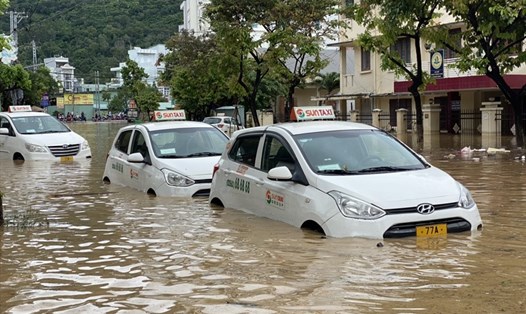 Nước ngập dâng cao kéo dài hơn 1km tại TP Quy Nhơn, hàng chục xe taxi đậu ven đường không kịp di chuyển bị nước nhấn chìm. Ảnh: D.P.