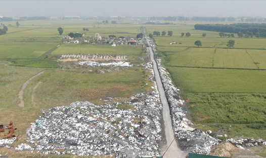 Người dân đổ trộm rác thải tại khu đất sát nghĩa địa của làng. Ảnh: PV.