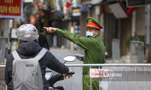 Lực lượng chức năng phường Phú Đô (quận Nam Từ Liêm) túc trực để nhắc nhở người dân không ra, vào khu vực phong tỏa. Ảnh Tô Thế