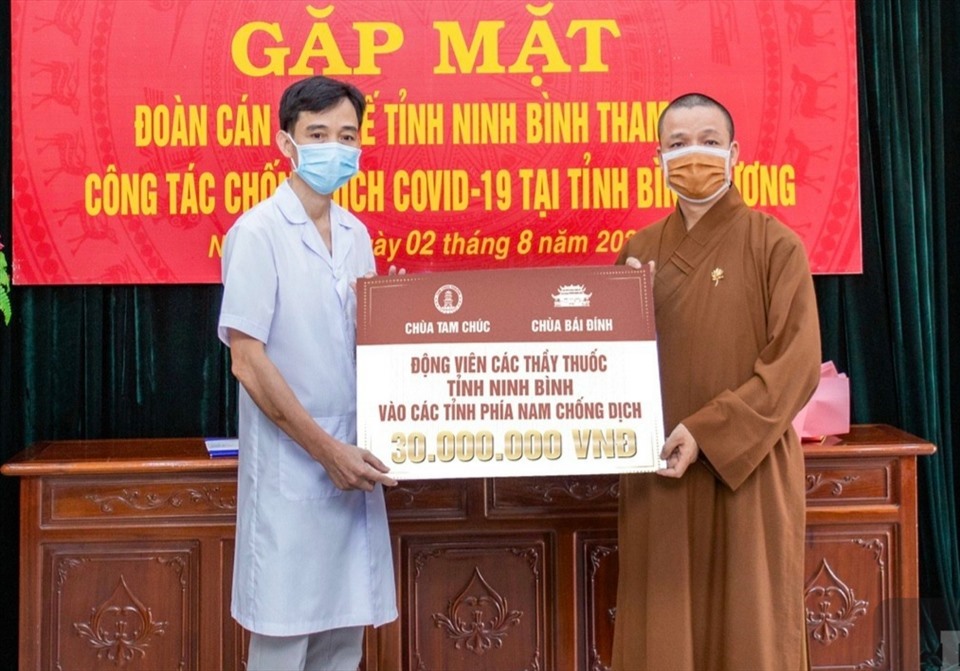 Thượng tọa Thích Minh Quang, Phó Trưởng Ban, Chánh Thư ký Ban Trị sự GHPG Việt Nam tỉnh Ninh Bình trao số tiền 30 triệu đồng hỗ trợ Đoàn cán bộ y tế tỉnh Ninh Bình tham gia chống dịch tại các tỉnh phía Nam. Ảnh: NT