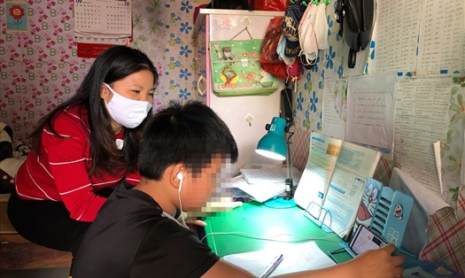 Chị Dương Thị Tuyên (công nhân khu công nghiệp Thăng Long, Đông Anh, Hà Nội) đang trông con học online. Ảnh: Bảo Hân