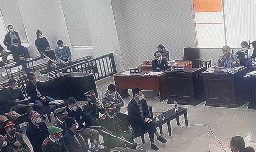 Các bị cáo trong phiên toà xét xử vụ sai phạm tại dự án cao tốc Đà Nẵng - Quảng Ngãi nghe đại diện cơ quan giám định tư pháp (cầm micro, góc phải) giải thích. Ảnh chụp qua màn hình