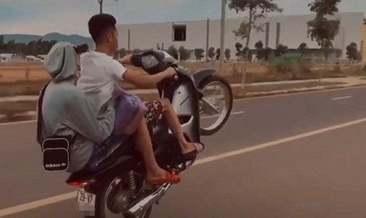 Hai thanh niên đi xe máy không đội mũ bảo hiểm, "bốc đầu" rồi đưa lên mạng xã hội. Ảnh: Cắt từ clip