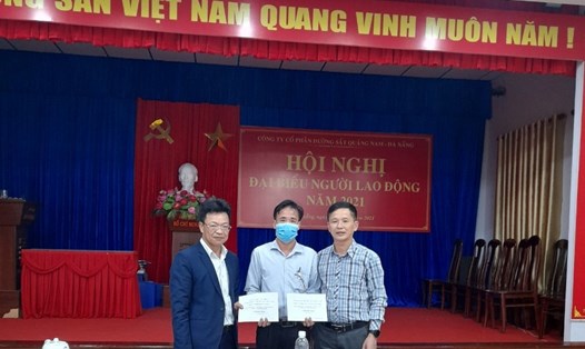 Các ông Đặng Sỹ Mạnh (ngoài cùng, bên trái) và Nguyễn Thanh Hoàn (ngoài cùng,  bên phải) trao hỗ trợ cho đại diện Công đoàn đơn vị của chị Trần Thị Thắm. Ảnh: CĐN
