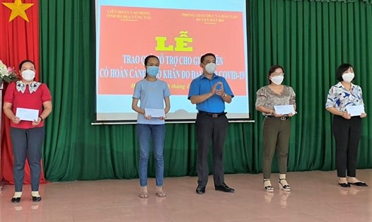 Ông Huỳnh Sơn Tuấn - Chủ tịch LĐLĐ tỉnh trao quà hỗ trợ cho các giáo viên có hoàn cảnh khó khăn huyện Đất Đỏ. Ảnh: LĐLĐ