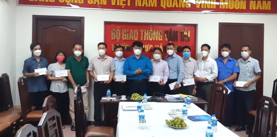 Ông Đỗ Nga Việt - Chủ tịch Công đoàn Giao thông Vận tải Việt Nam (thứ 6 từ trái sang) - trao hỗ trợ cho NLĐ khó khăn do COVID-19. Ảnh: CĐGT
