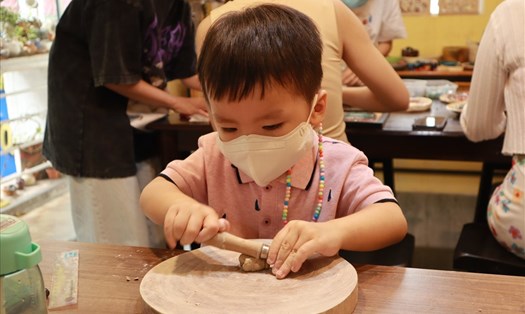 Em bé thích thú tự tay mình tạo ra những sản phẩm từ đất sét. Ảnh: Nguyễn Ly