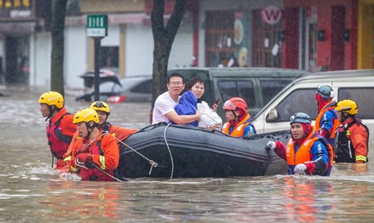 Lực lượng cứu hộ sơ tán những người bị mắc kẹt khỏi một con phố ngập lụt vào ngày 25.7 ở tỉnh Chiết Giang, Trung Quốc, sau khi bão In-fa đổ bộ với mưa lớn và gió mạnh. Ảnh: Xinhua