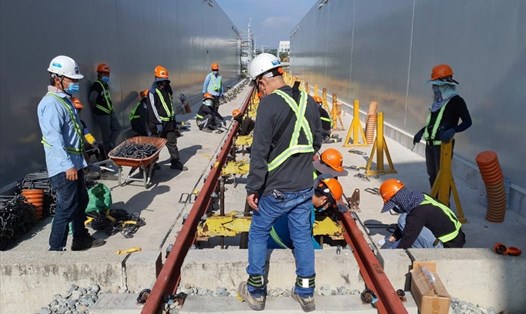 Công nhân thi công lắp đường ray thuộc gói thầu CP3 thuộc tuyến metro số 1 (Bến Thành - Suối Tiên, TPHCM). Ảnh: MAUR