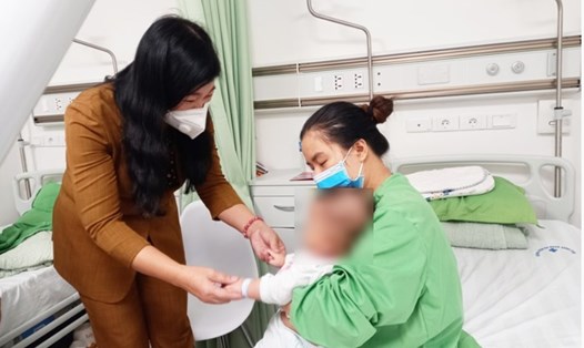 Bà Nguyễn Lan Hương thăm hỏi một em bé đang được theo dõi tại Bệnh viện Đa khoa Xanh Pôn. Ảnh: HNP