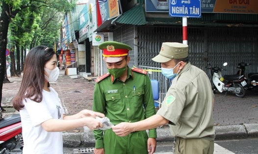 Lực lượng chức năng phường Nghĩa Tân (quận Cầu Giấy) tuyên truyền về việc đảm bảo trật tự an toàn giao thông - trật tự đô thị cho người dân. Ảnh Vân Nhi