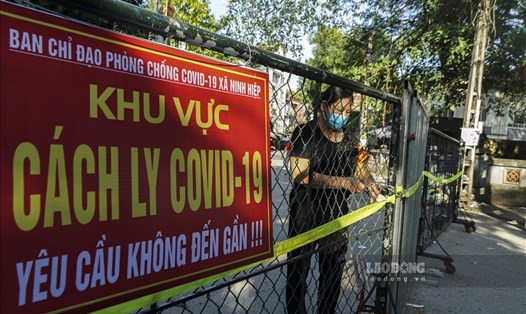 Lực lượng chức năng rào chắn, giãn cách toàn bộ xã Ninh Hiệp với 19.000 dân. Ảnh: Tùng Giang