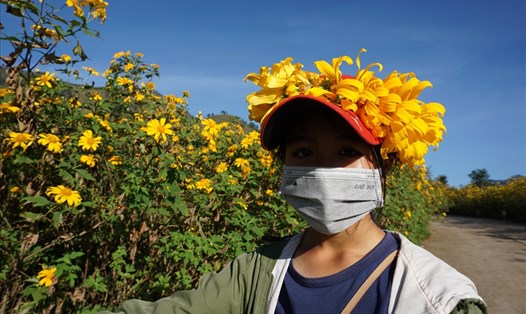 Một em nhỏ Gia Lai lên núi lửa bán vòng hoa cho du khách, hoa do chính em kết lại. Ảnh T.T