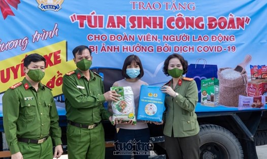 Trung tá Công Thanh Thảo - Chủ tịch Công đoàn Công an Nhân dân (bên phải) trao quà cho đoàn viên. Ảnh: Tuoitrethudo