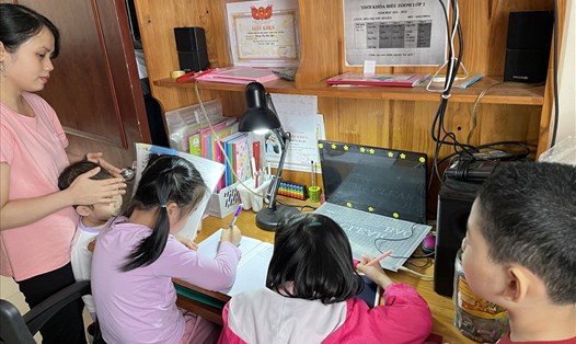 Nữ công nhân khu công nghiệp Thăng Long (Đông Anh, Hà Nội) phải nghỉ việc để ở nhà trông con và dạy con học online. Ảnh: Hà Anh
