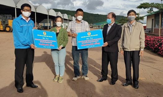 Ông Lê Ngọc Phúc - Phó Chủ tịch Liên đoàn Lao động tỉnh Lâm Đồng (bên trái) - trao hỗ trợ công nhân lao động bị ảnh hưởng bởi dịch bệnh COVID-19. Ảnh: Ngọc Mai