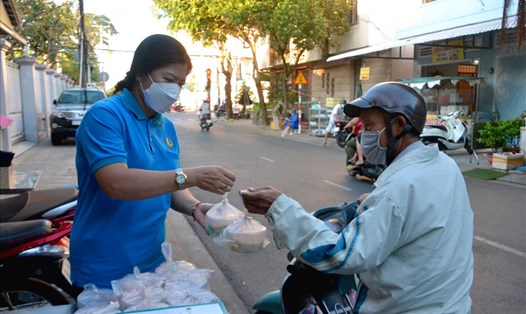 Phó Chủ tịch Thường trực LĐLĐ tỉnh Kiên Giang Nguyễn Thị Hoàn Xuân trao túi cháo cho một lao động nghèo. Ảnh: LT