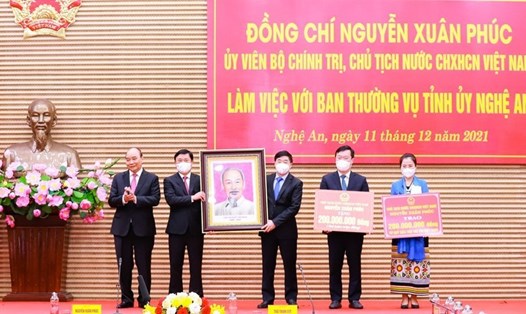 Chủ tịch nước Nguyễn Xuân Phúc tặng quà lưu niệm và trao các phần quà an sinh xã hội cho tỉnh Nghệ An. Ảnh: Thành Duy/Báo NA