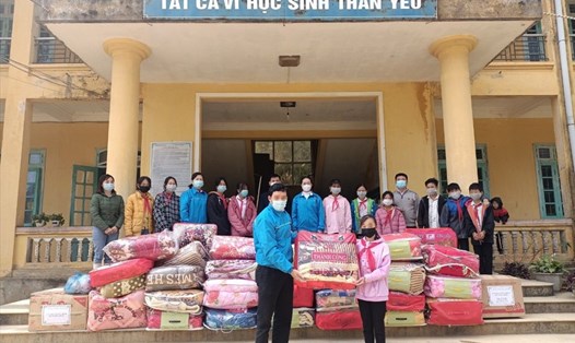 Lãnh đạo LĐLĐ huyện Na Hang tặng chăn, áo ấm cho học sinh khó khăn. Ảnh: CĐCC