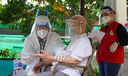 Cán bộ Y tế TPHCM đến tận nhà khám sàng lọc và tiêm vaccine cho người lớn tuổi. Ảnh: Chân Phúc